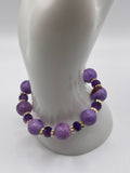 Purple Persian Gulf Chalcedony bracelet with 18K gold flower spacers and amethyst rondelles on display stand