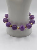 Purple Persian Gulf Chalcedony stretch bracelet with 18K gold plated round spacers on display stand