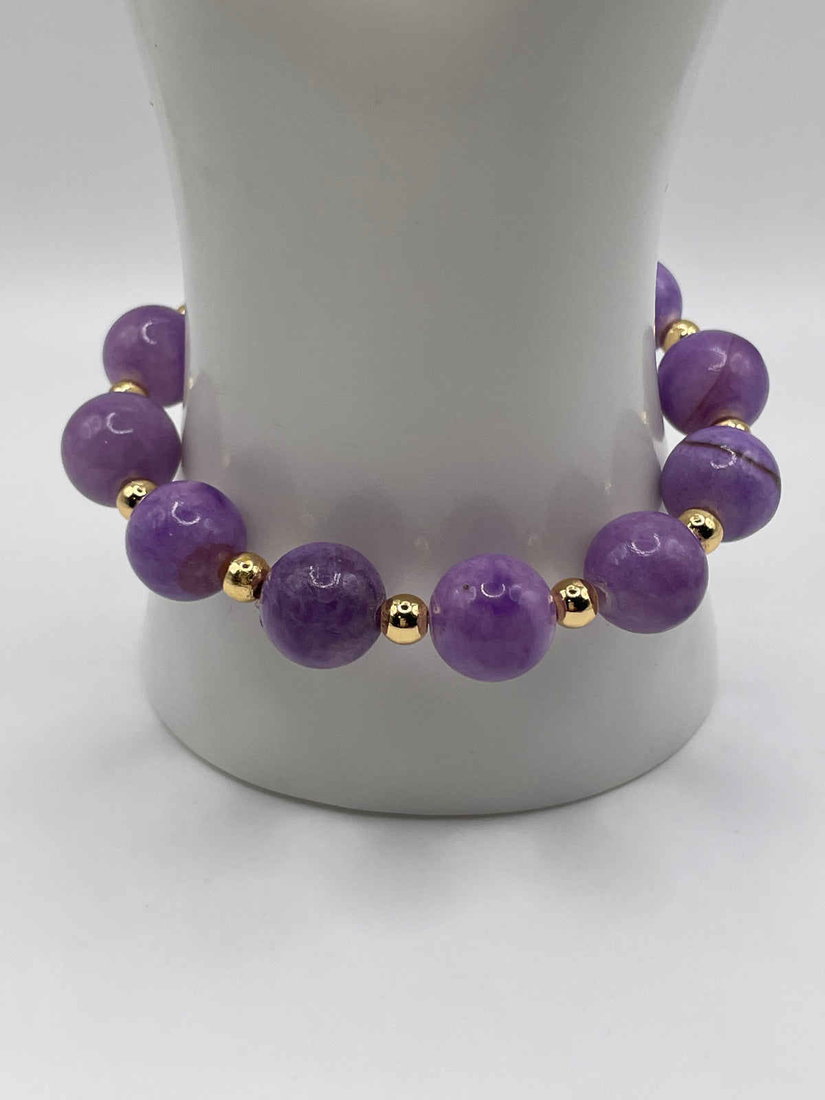 Purple Persian Gulf Chalcedony stretch bracelet with 18K gold plated round spacers on display stand