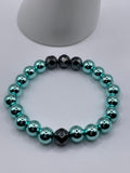 Cyan hematite and faceted black hematite stretch bracelet laid flat on white surface