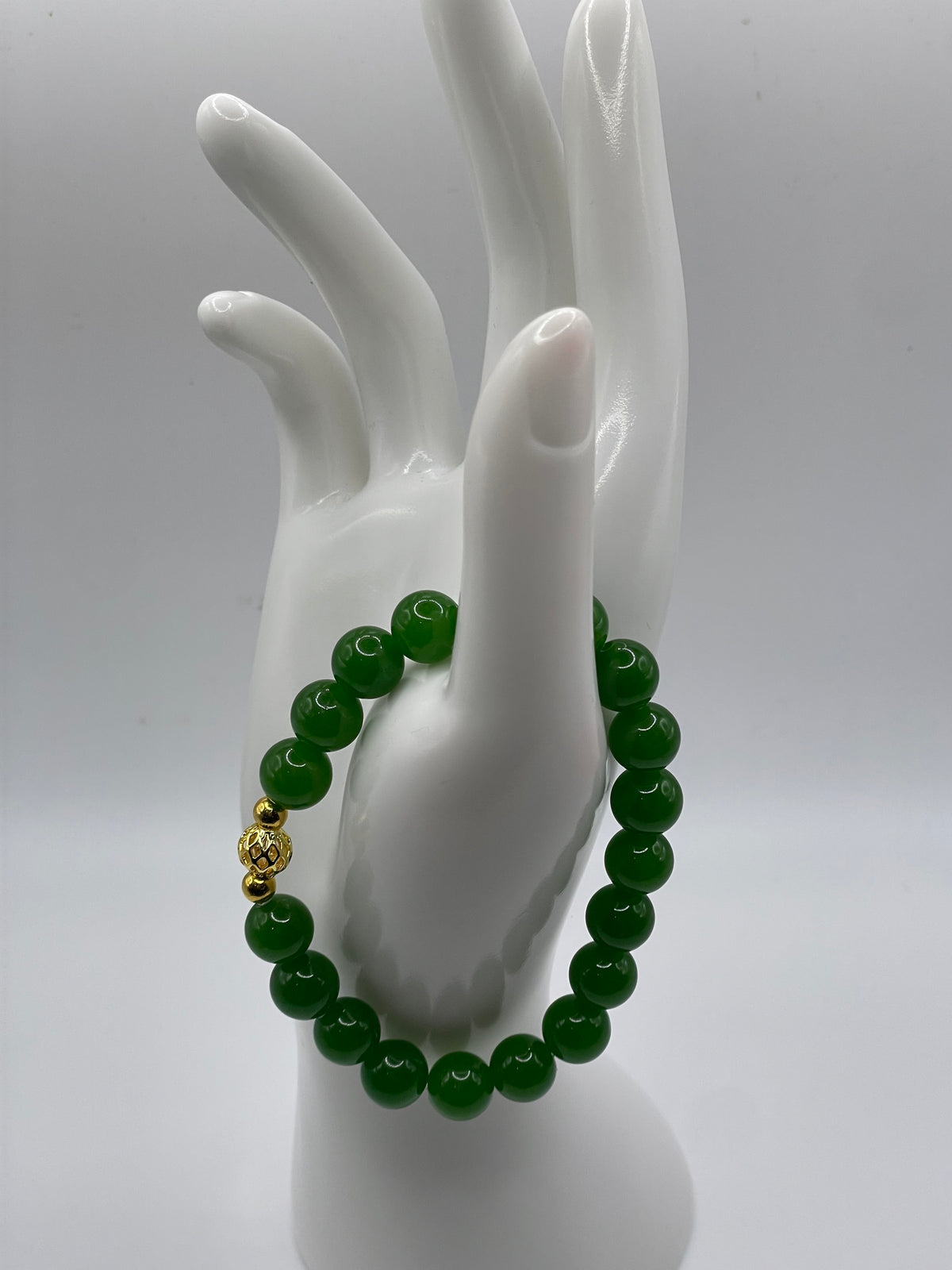 Raw jade bracelet with gold plated focal bead on hand display