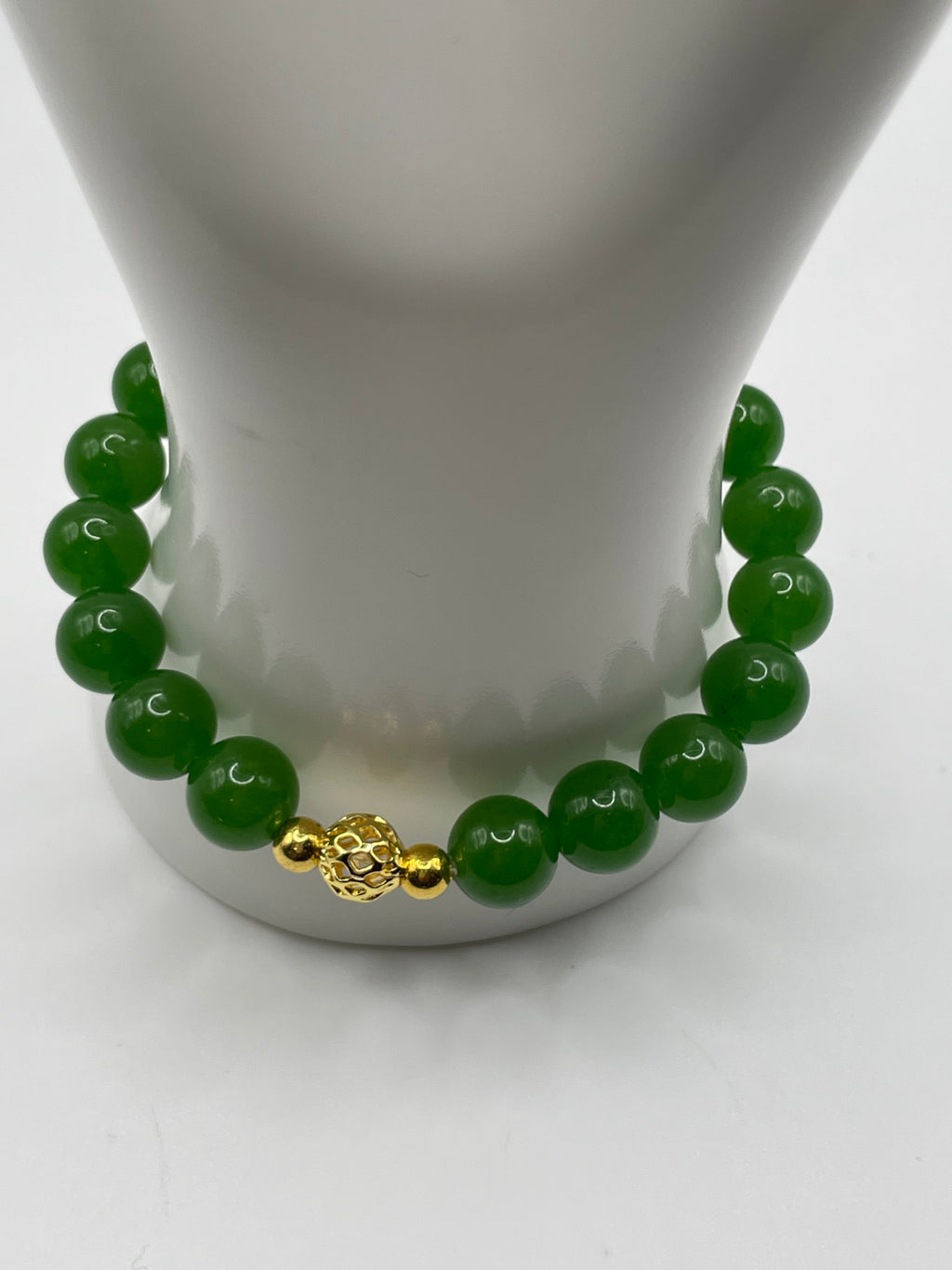 Raw jade bracelet with gold focal bead front view on display