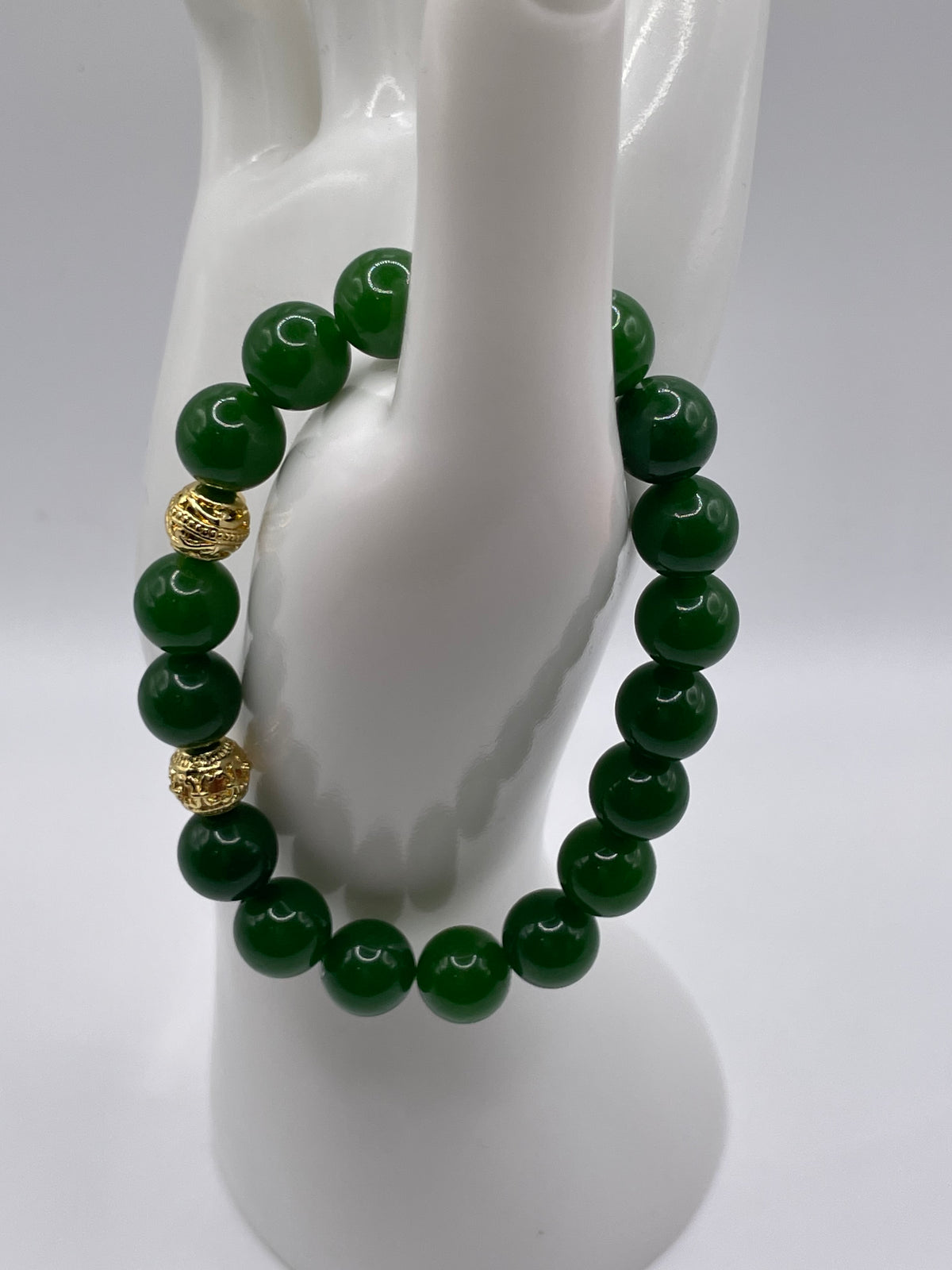 Raw jade bracelet with gold spacers side view on display hand