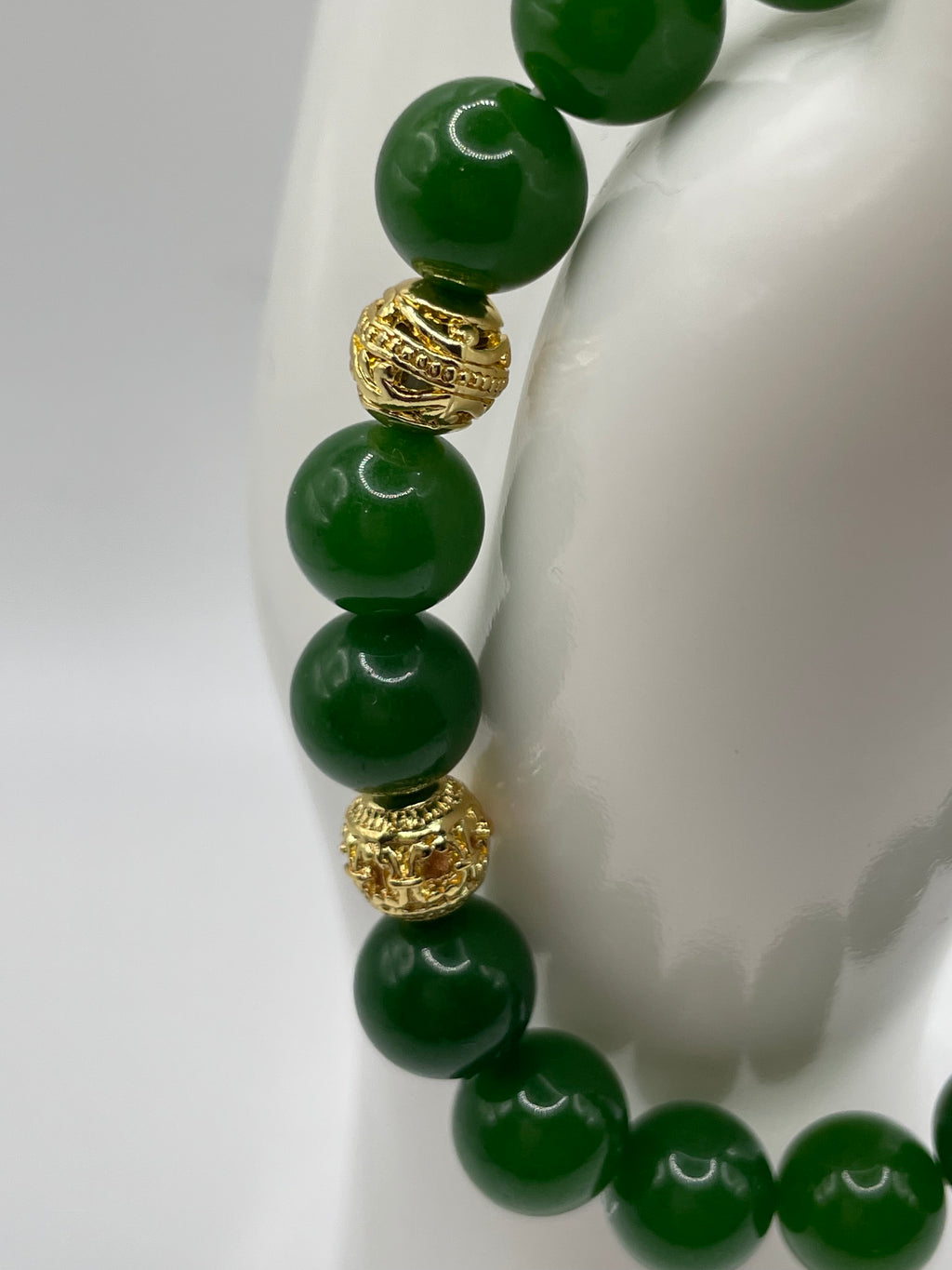 Close-up detail of ornate 18kt gold plated spacer beads on raw jade bracelet