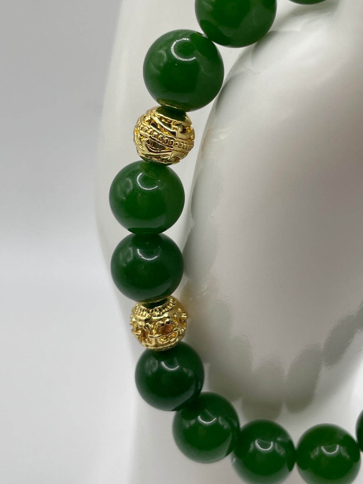 Close-up detail of ornate 18kt gold plated spacer beads on raw jade bracelet
