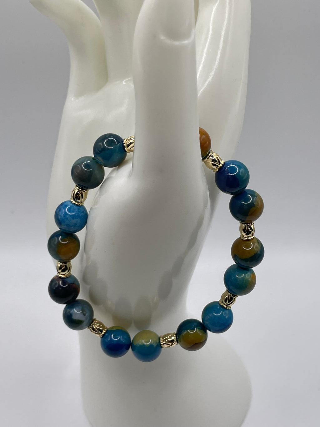 Blue and Yellow Agate Bead Bracelet 10mm with 8 gold spacers on hand display