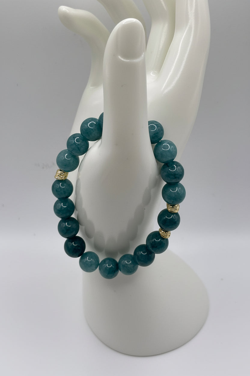 Aquamarine blue sponge agate bracelet with small gold spacers on hand display