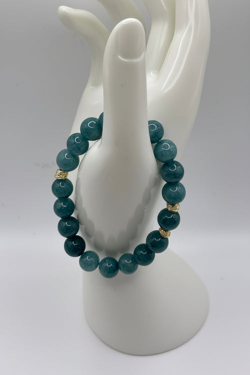 Aquamarine blue sponge agate bracelet with small gold spacers on hand display