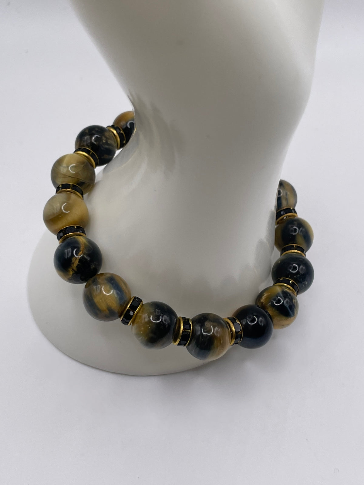 12mm Dream Tiger Eye bracelet with black and gold rhinestone spacers on mannequin wrist display