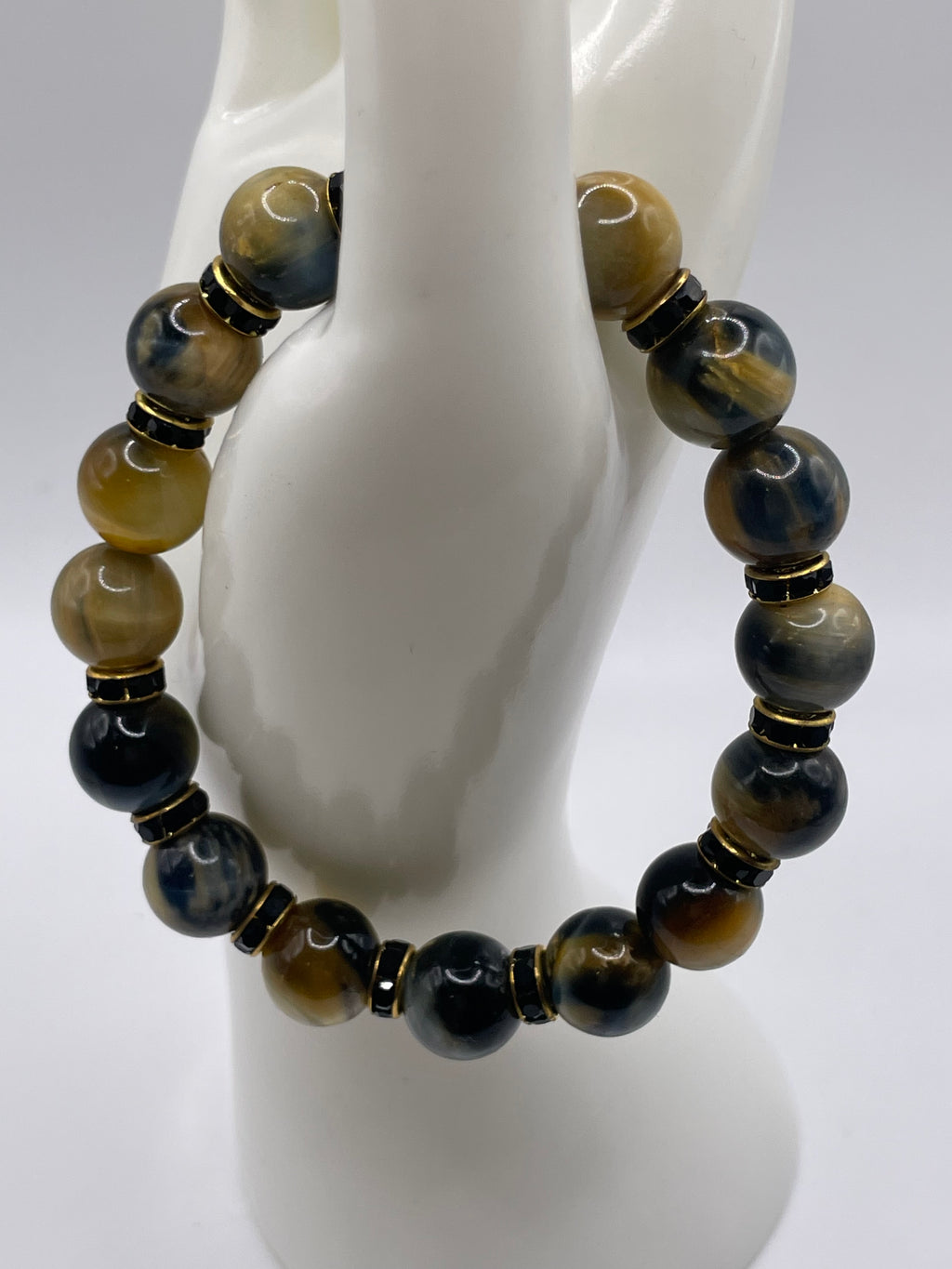 12mm Dream Tiger Eye bracelet with black and gold rhinestone spacers overhead view on mannequin