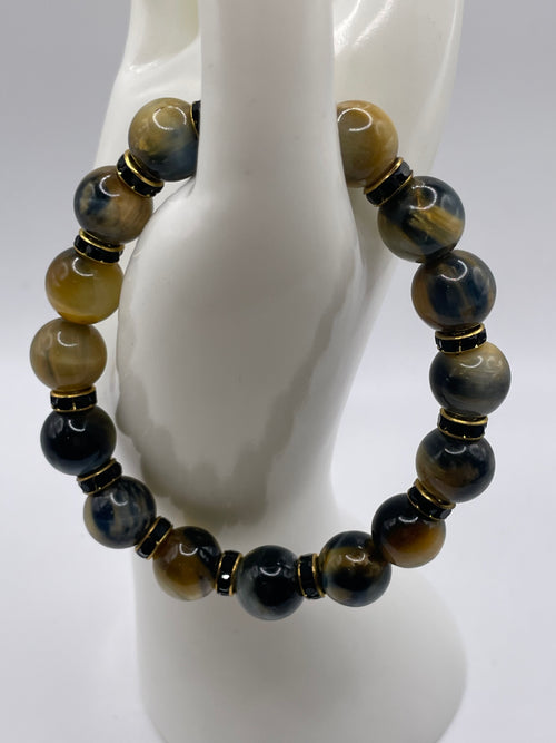12mm Dream Tiger Eye bracelet with black and gold rhinestone spacers overhead view on mannequin