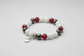 Bracelet with white, red, and black tint in beads on a wooden surface