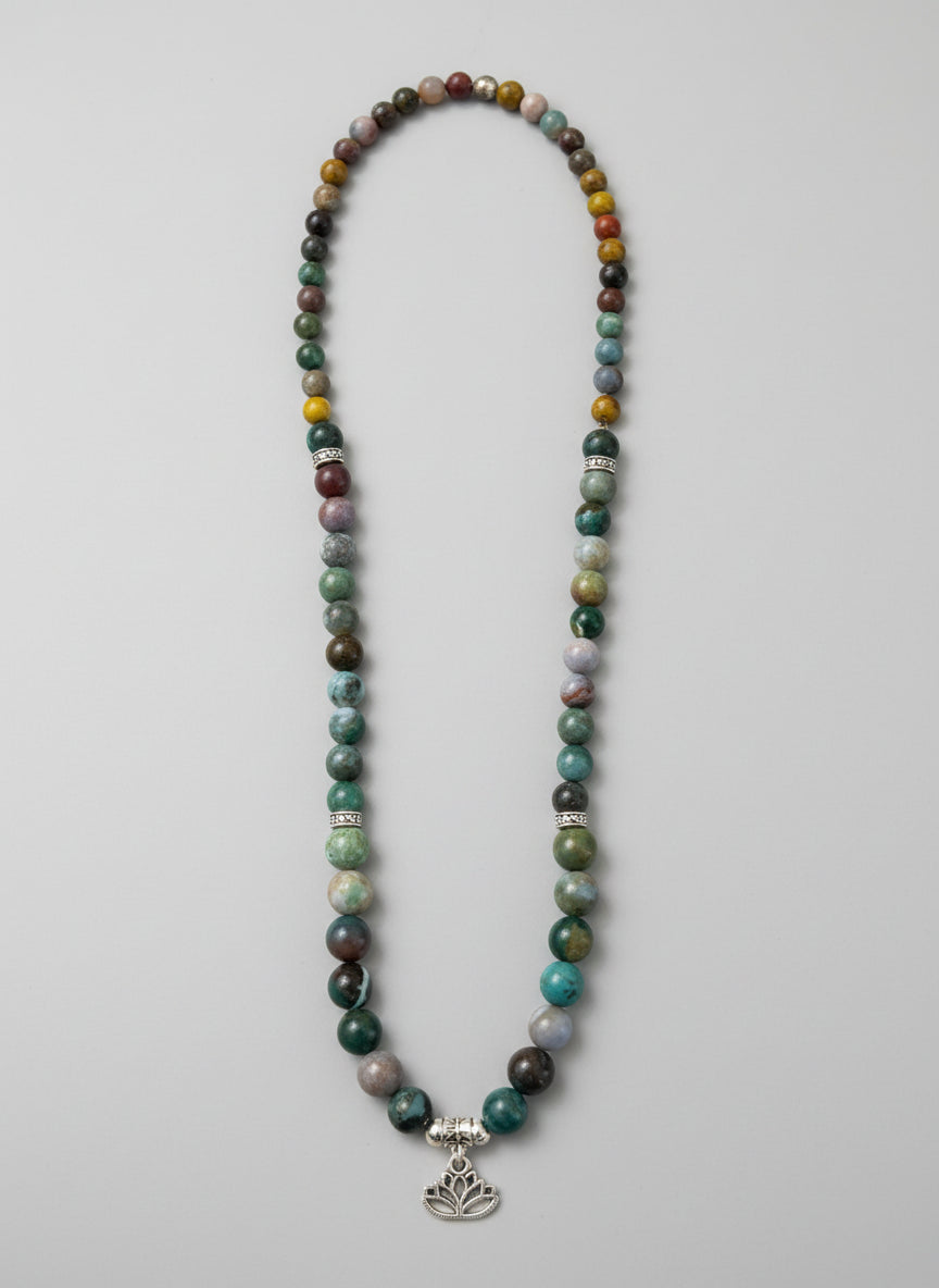 Beaded necklace with a tree of life charm on a wooden surface