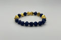 Bracelet with blue and gold beads on a light gray background