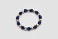 Bracelet with blue and gold beads on a wooden surface