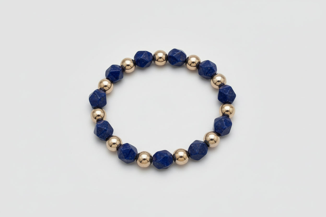 Bracelet with blue and gold beads on a wooden surface