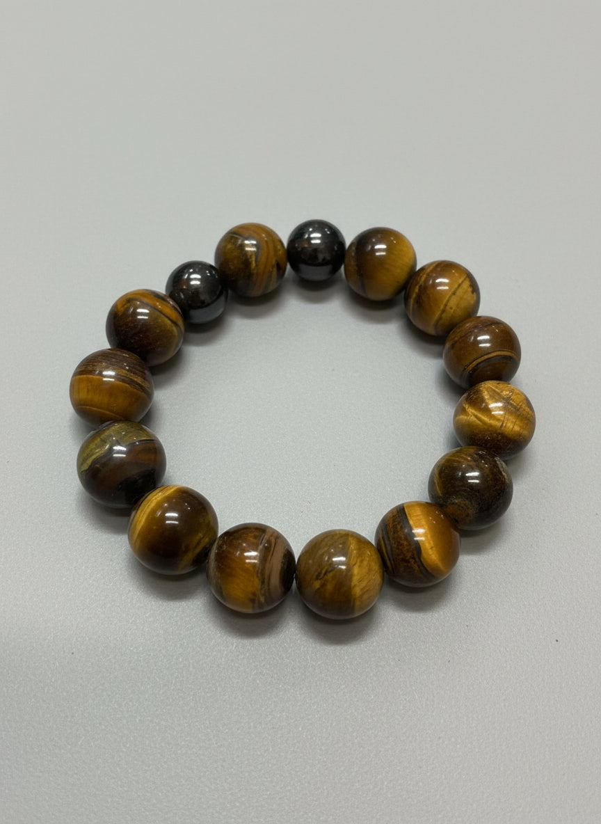 Beaded bracelet made of tiger eye stones and two hematite on a wooden surface