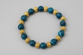 Bracelet with blue and gold beads on a wooden surface