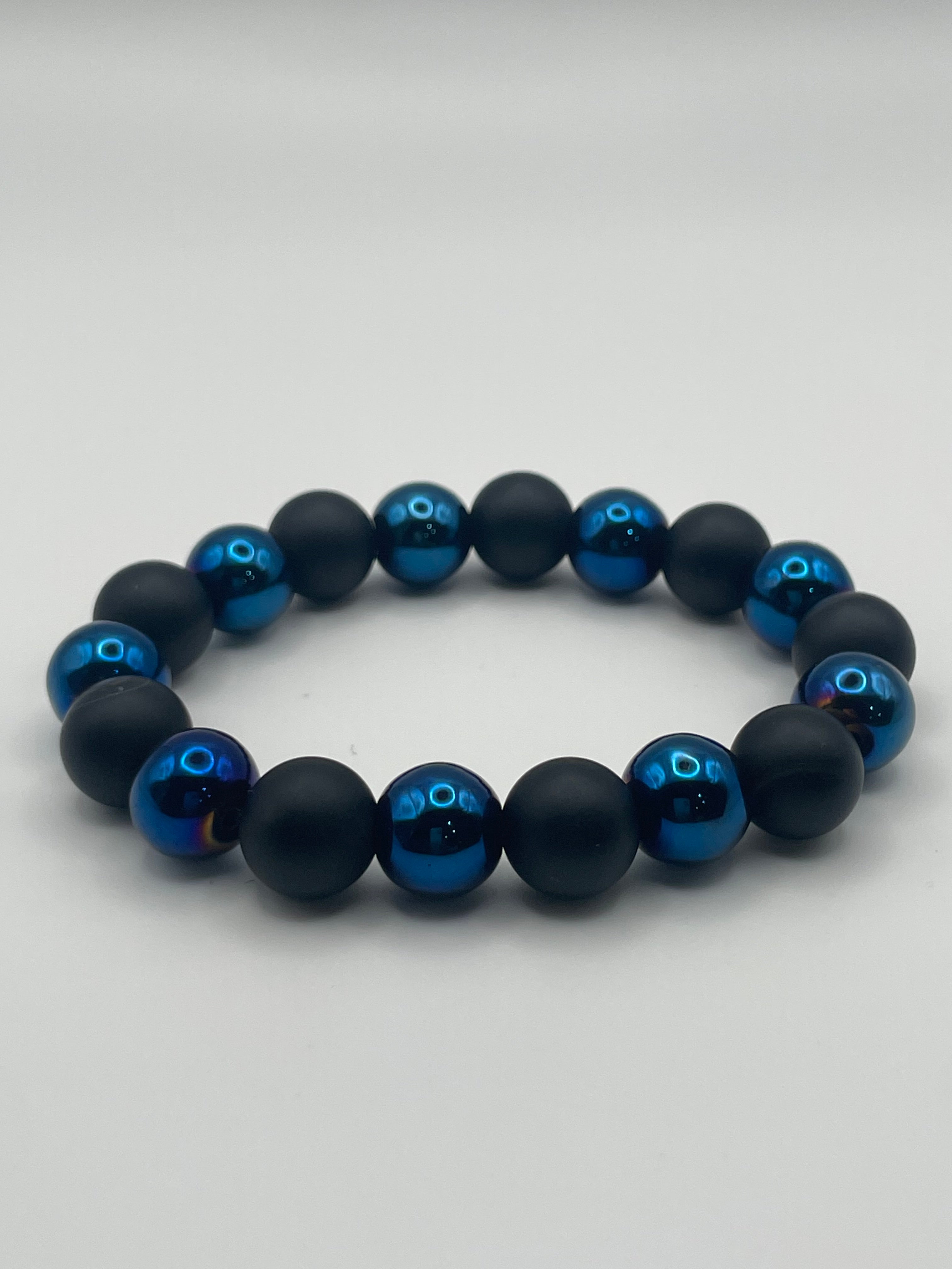 Black and blue beaded bracelet on a light gray background