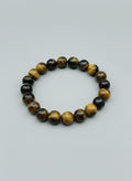 Beaded bracelet with black and yellow beads on a light gray background