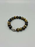 Beaded bracelet with a silver bead on a wooden surface