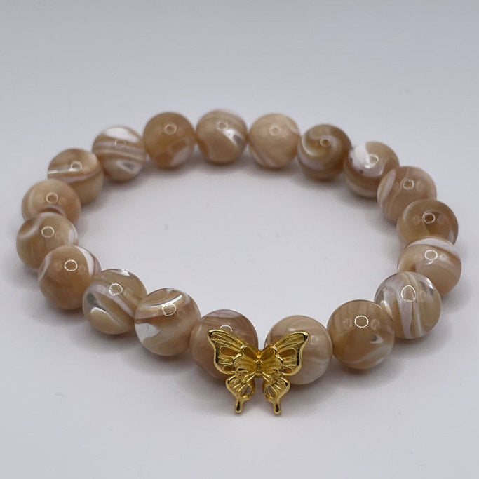 Beaded bracelet with a gold charm on a white background
