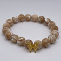 Beaded bracelet with a gold charm on a white background