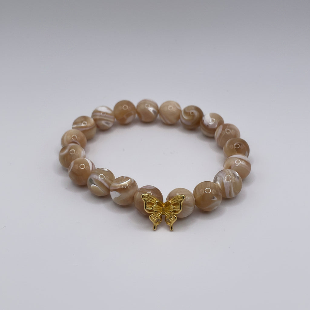 Beaded bracelet with a gold charm on a white background