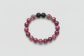 Bracelet with purple and black lava beads on a wooden surface