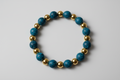 Bracelet with blue and gold beads on a wooden surface