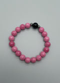 Pink beaded bracelet on a wooden surface