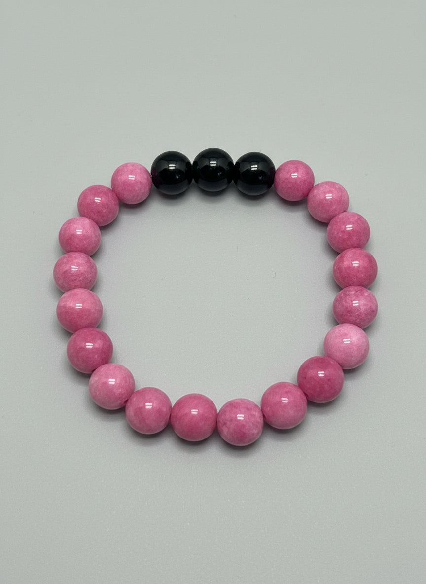 Pink and onyx beaded bracelet on a wooden surface