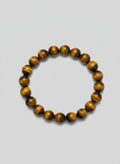 Beaded bracelet with brown and golden stones on a wooden surface
