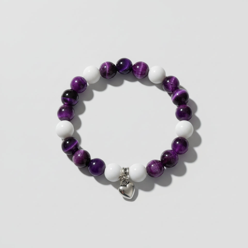 Bracelet with purple and white beads silver heart charm on a wooden surface