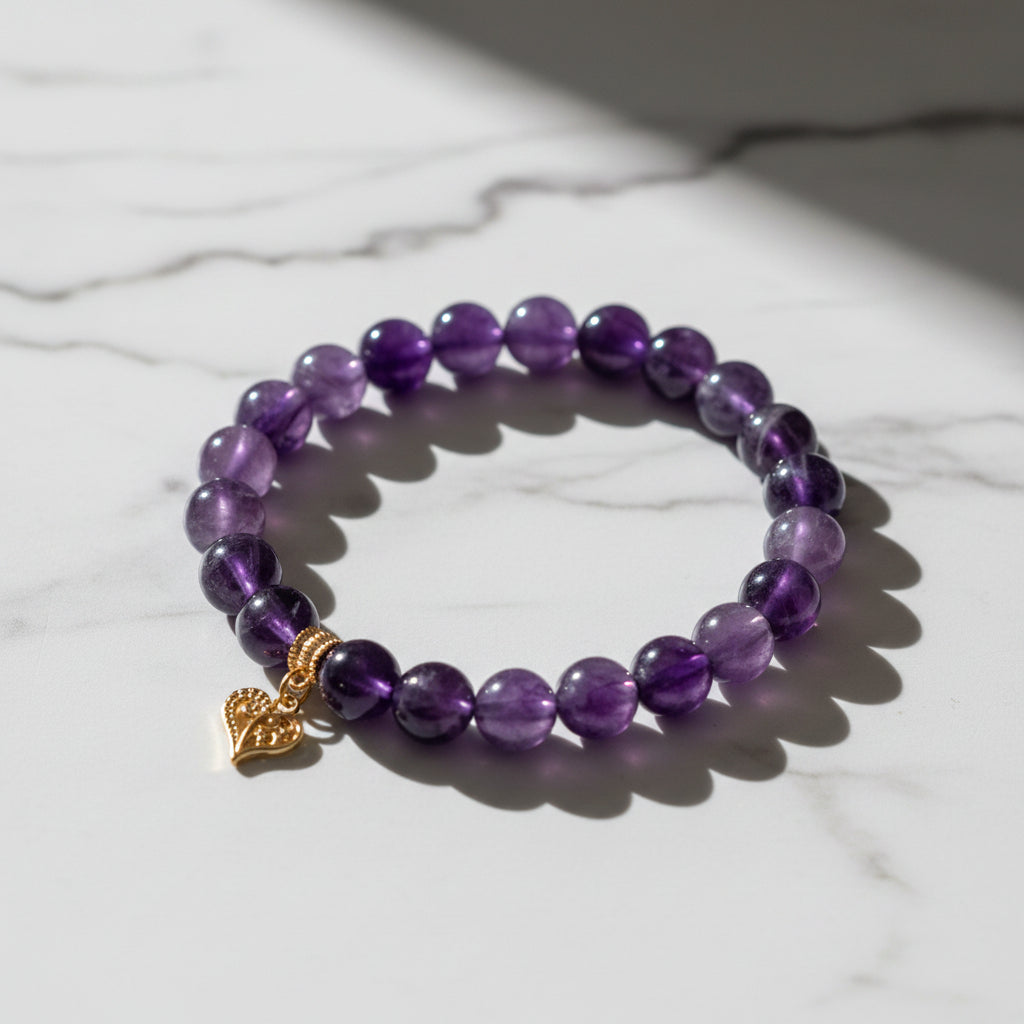 Purple beaded bracelet with a gold heart charm on a wooden surface