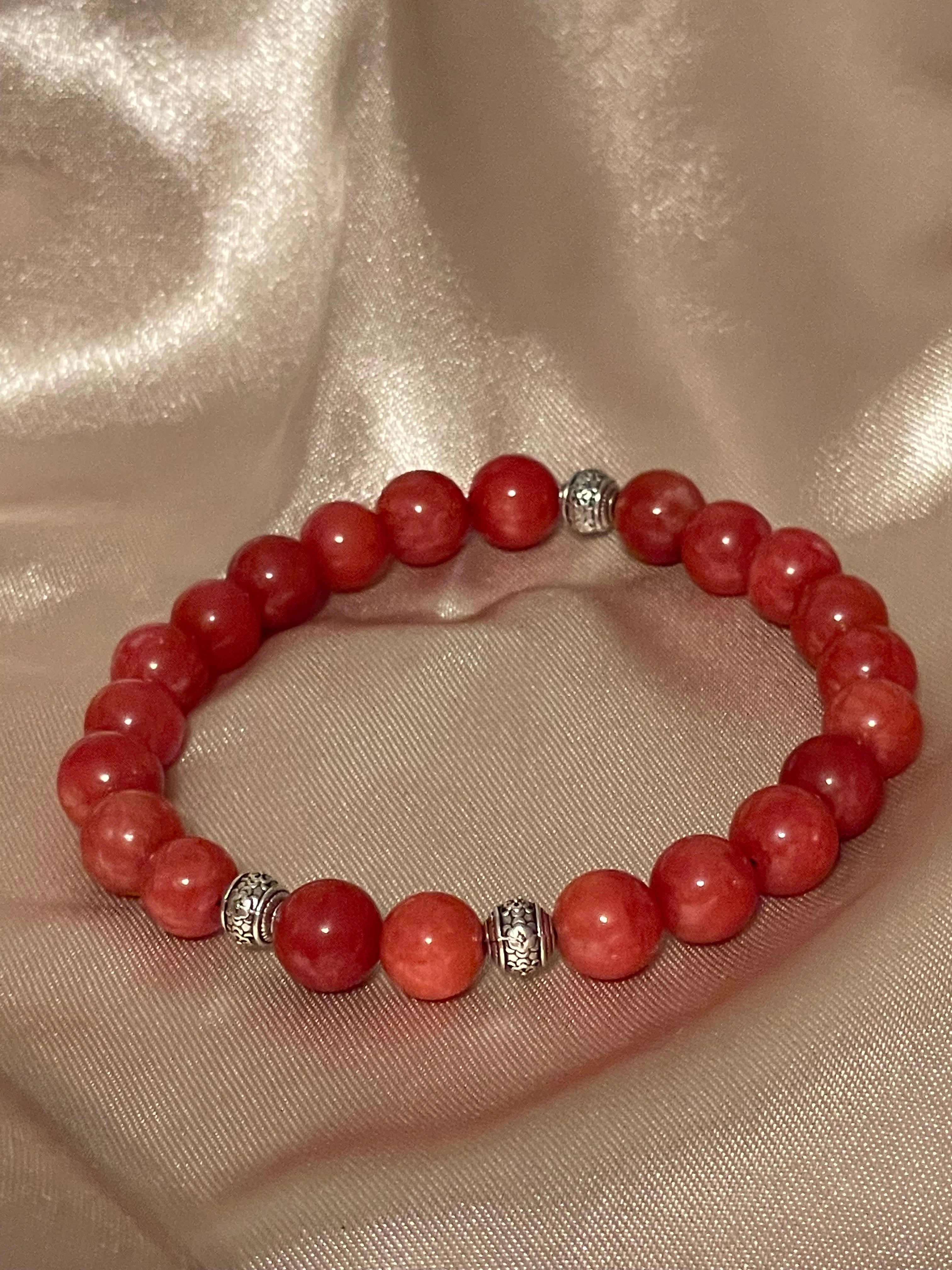 Red Chalcedony Stone bracelet with silver beads on a beige fabric background