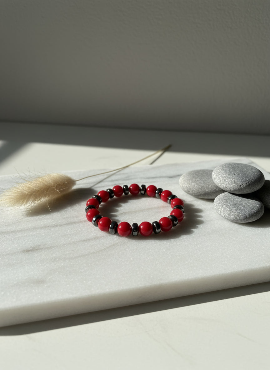 Red and black beaded bracelet on a beige fabric background