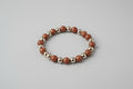 Bracelet with red and silver beads on a wooden surface