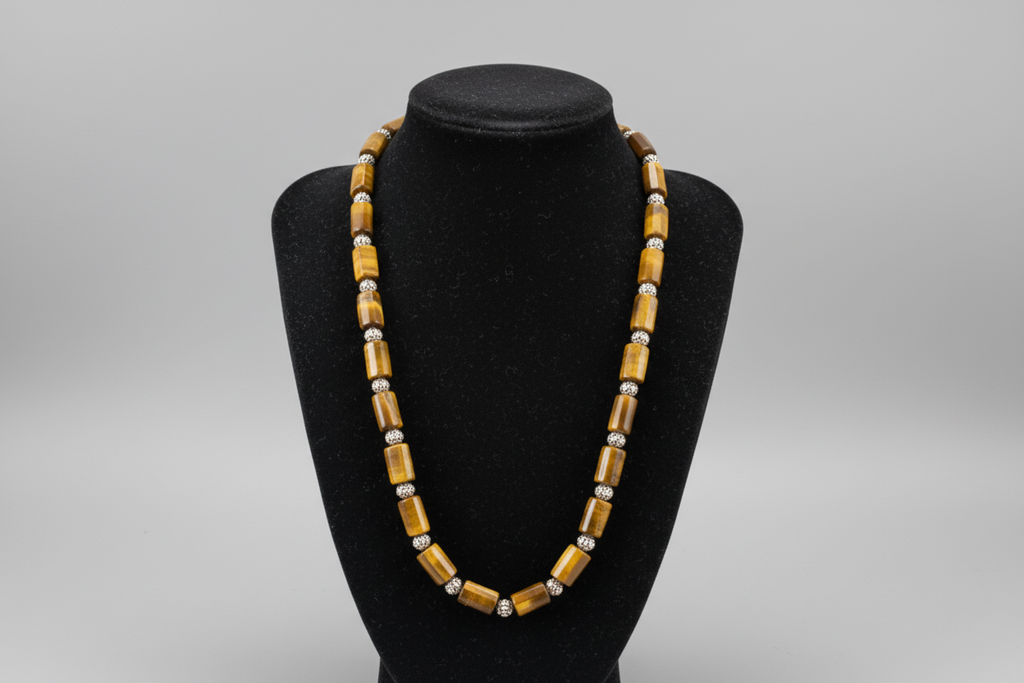 Beaded necklace on a black bust against a patterned surface