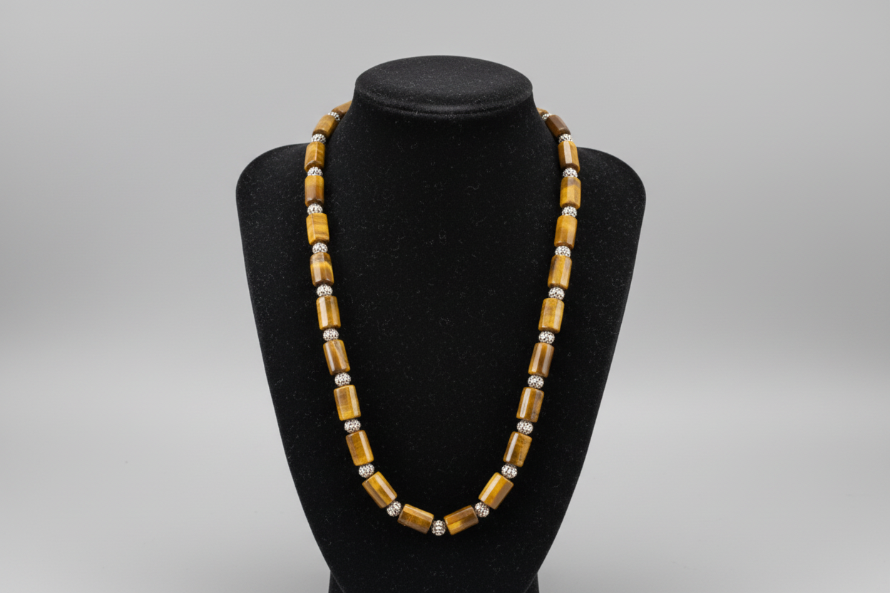 Beaded necklace on a black bust against a patterned surface