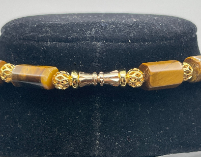 Gold and brown beaded bracelet on a black velvet background