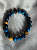 Golden and blue tiger eye beads come together on this bracelet stack, designed to boost confidence and focus. Each piece is a statement of strength and style.