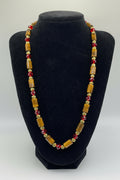 Necklace with brown and red beads on a black stand
