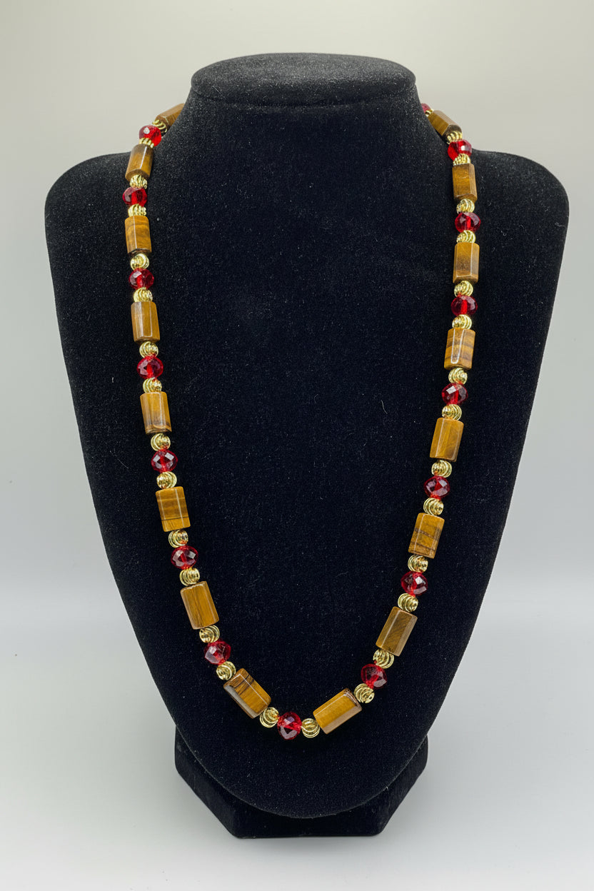 Necklace with brown and red beads on a black stand