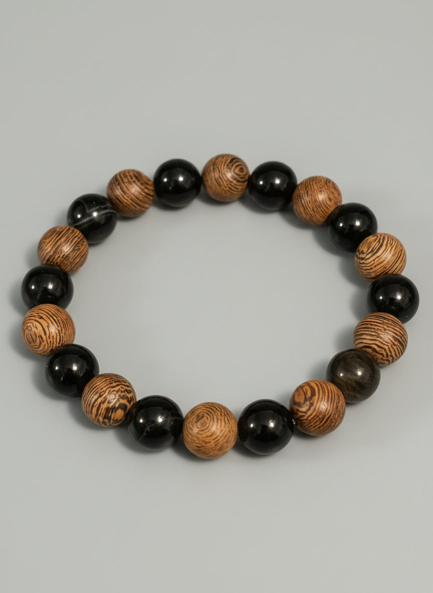 Wooden beaded bracelet with black and brown beads on a textured gray background