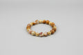 Bracelet with brown and gold beads on a wooden surface