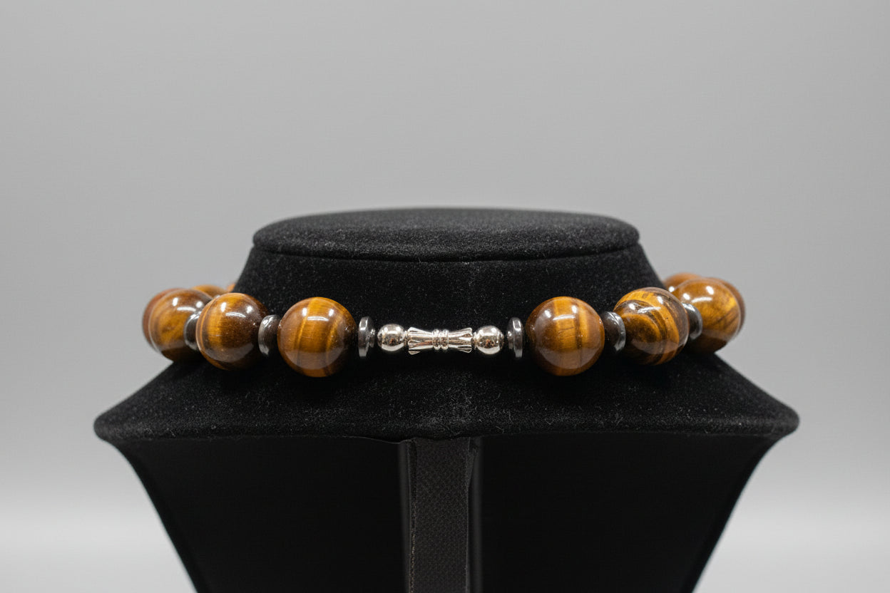 Bracelet with brown beads and silver accents on a black cushioned stand.