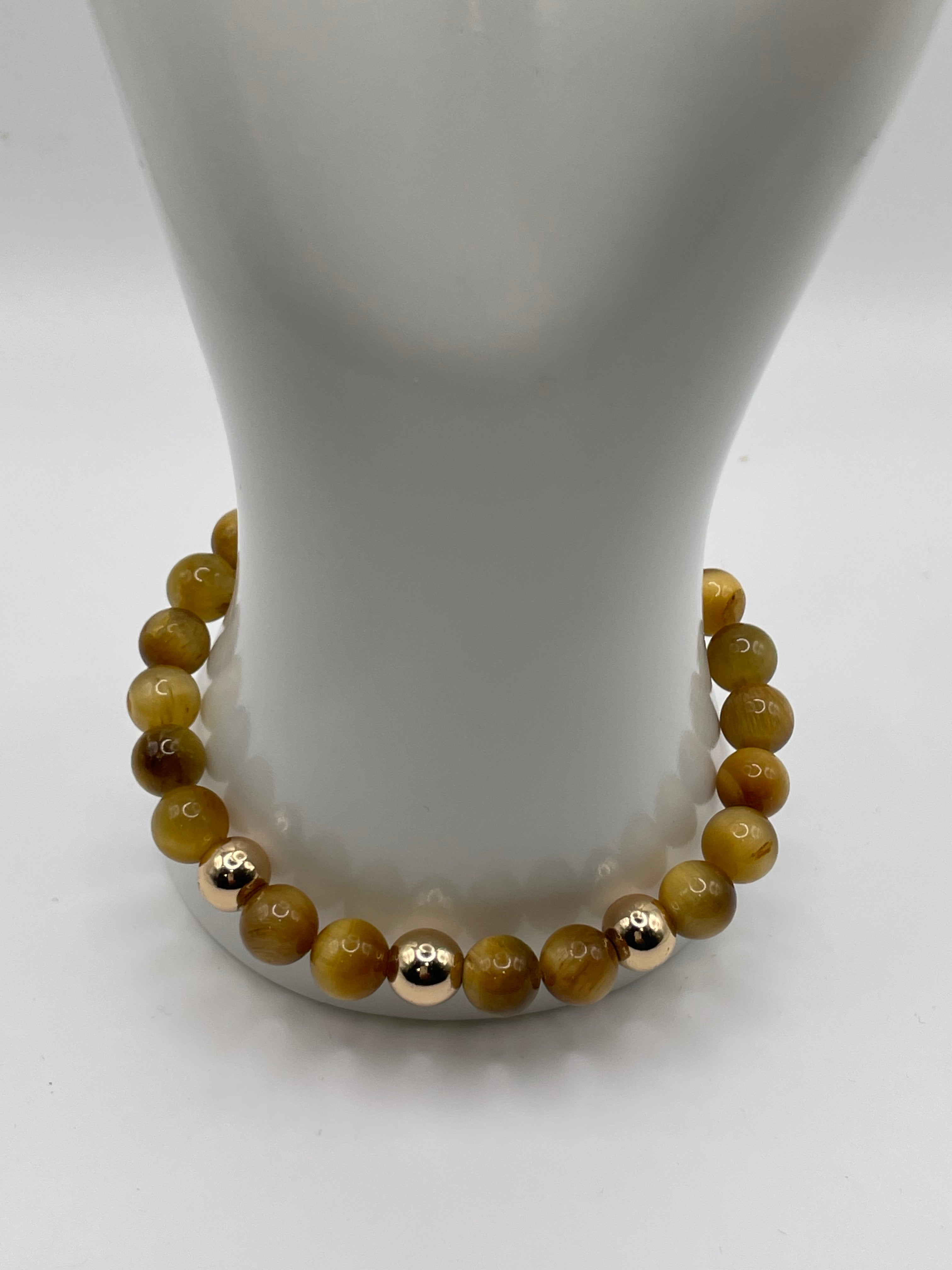 Beaded bracelet with gold accents on a white mannequin arm