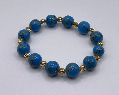Blue beaded bracelet with gold accents on a light gray background