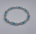 Bracelet with blue and gold beads on a white background